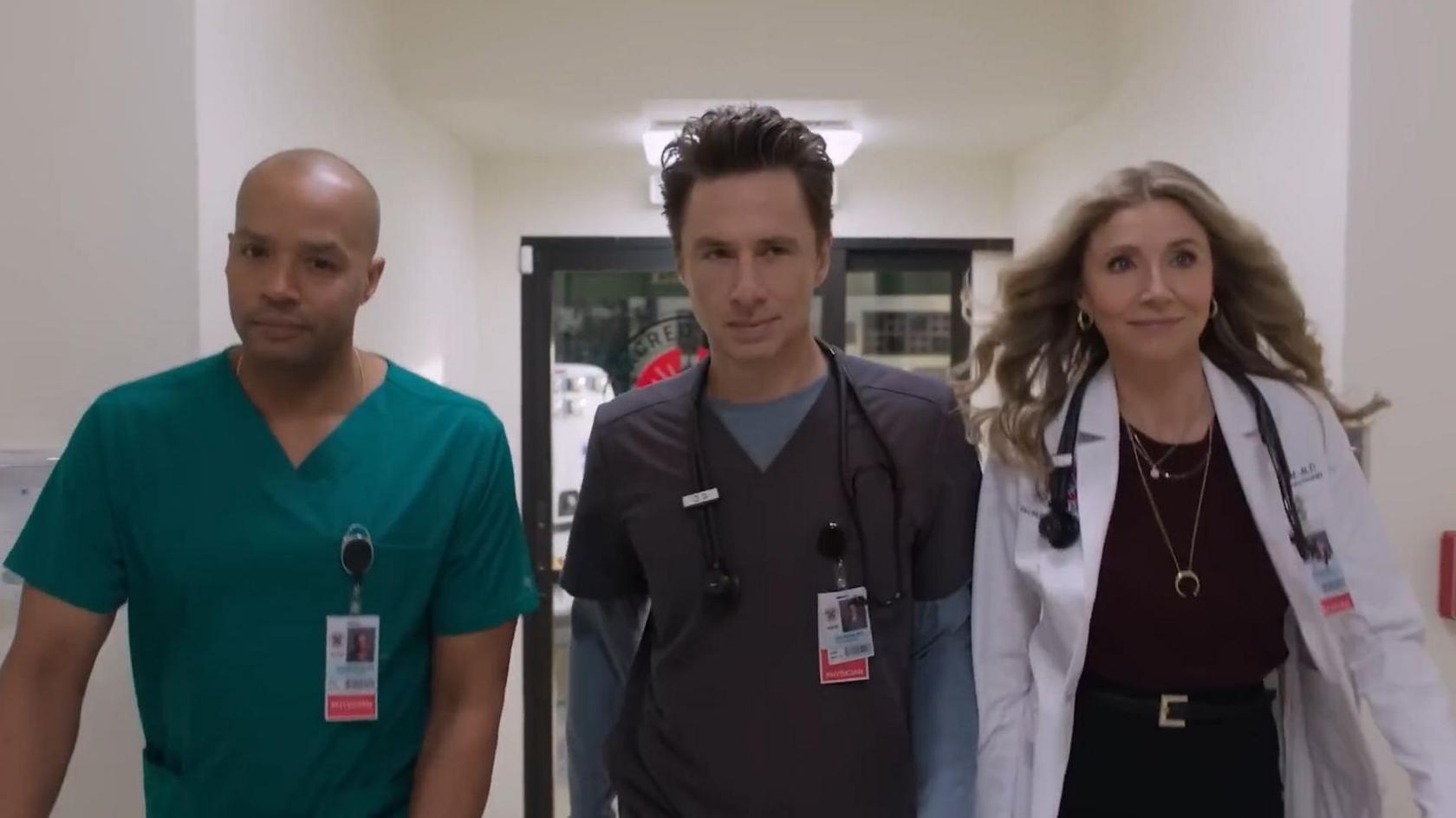 Three cast member walking down a hospital corridor