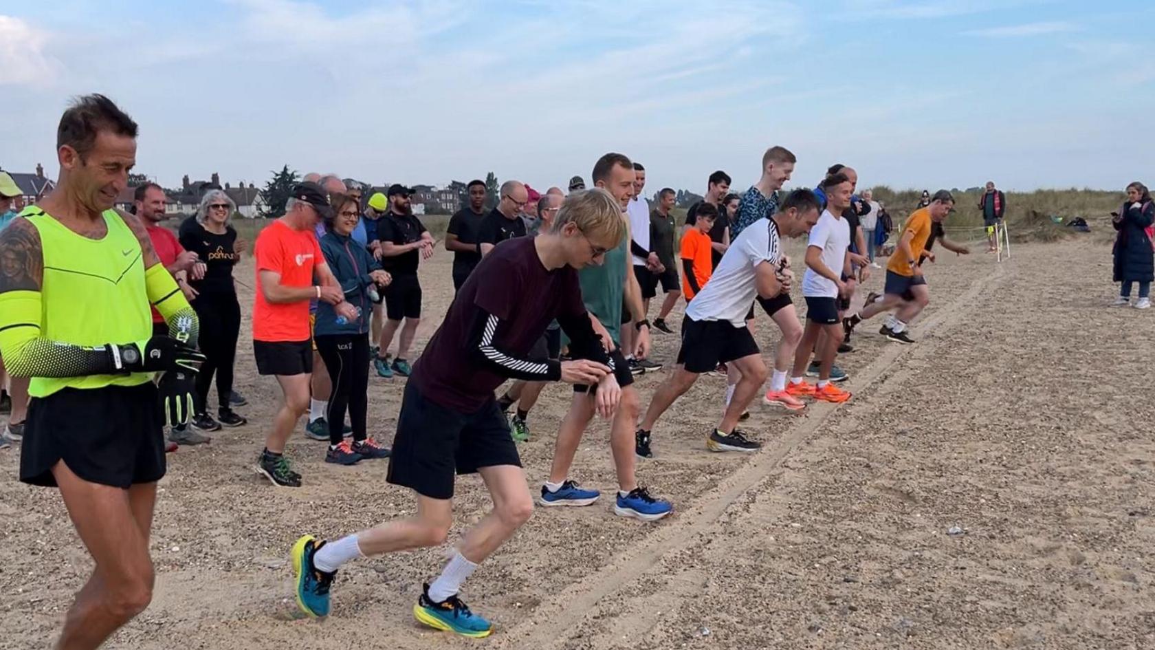 Runners about to set off from the starting line on the beach.