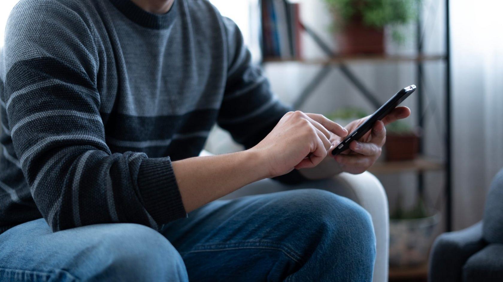 Person sat down holding phone