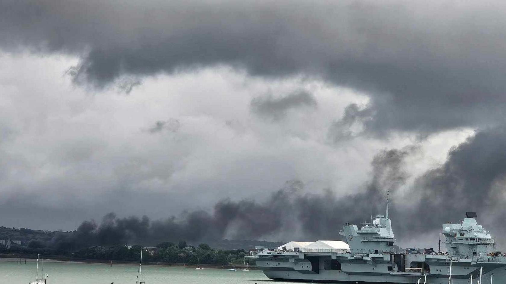 A large cloud of smoke hovering over a marina