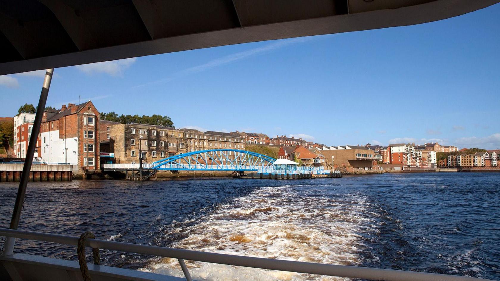 Photo from ferry looking at water and bridge on a sunny day