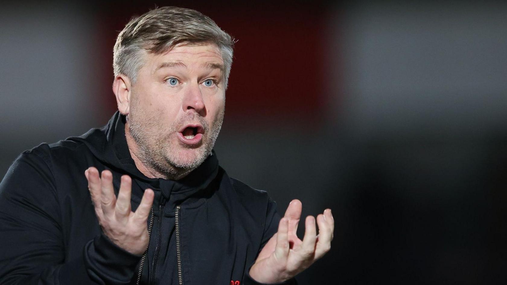 Karl Robinson stands on the touchline during a Salford City game