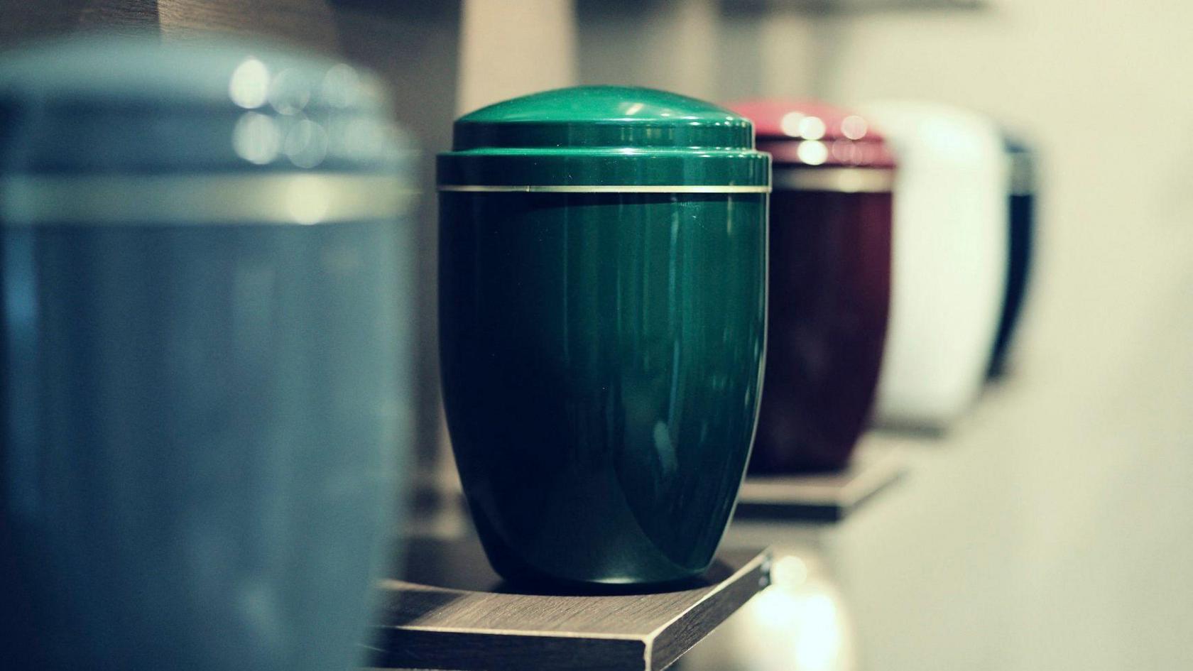 Funeral urns lined up on a shelf