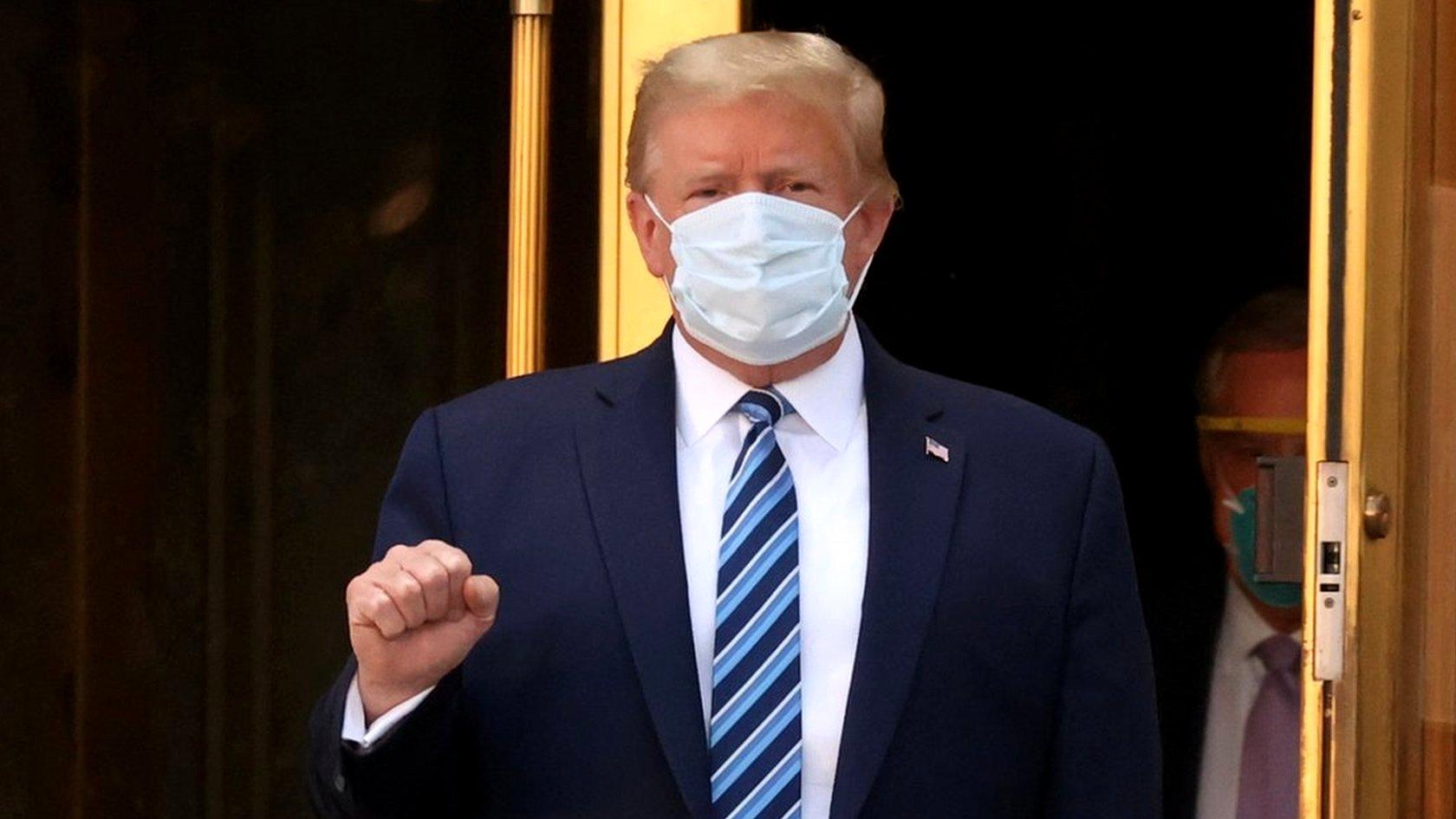 US President Donald Trump makes a fist as he walks leaves Walter Reed National Military Medical Center