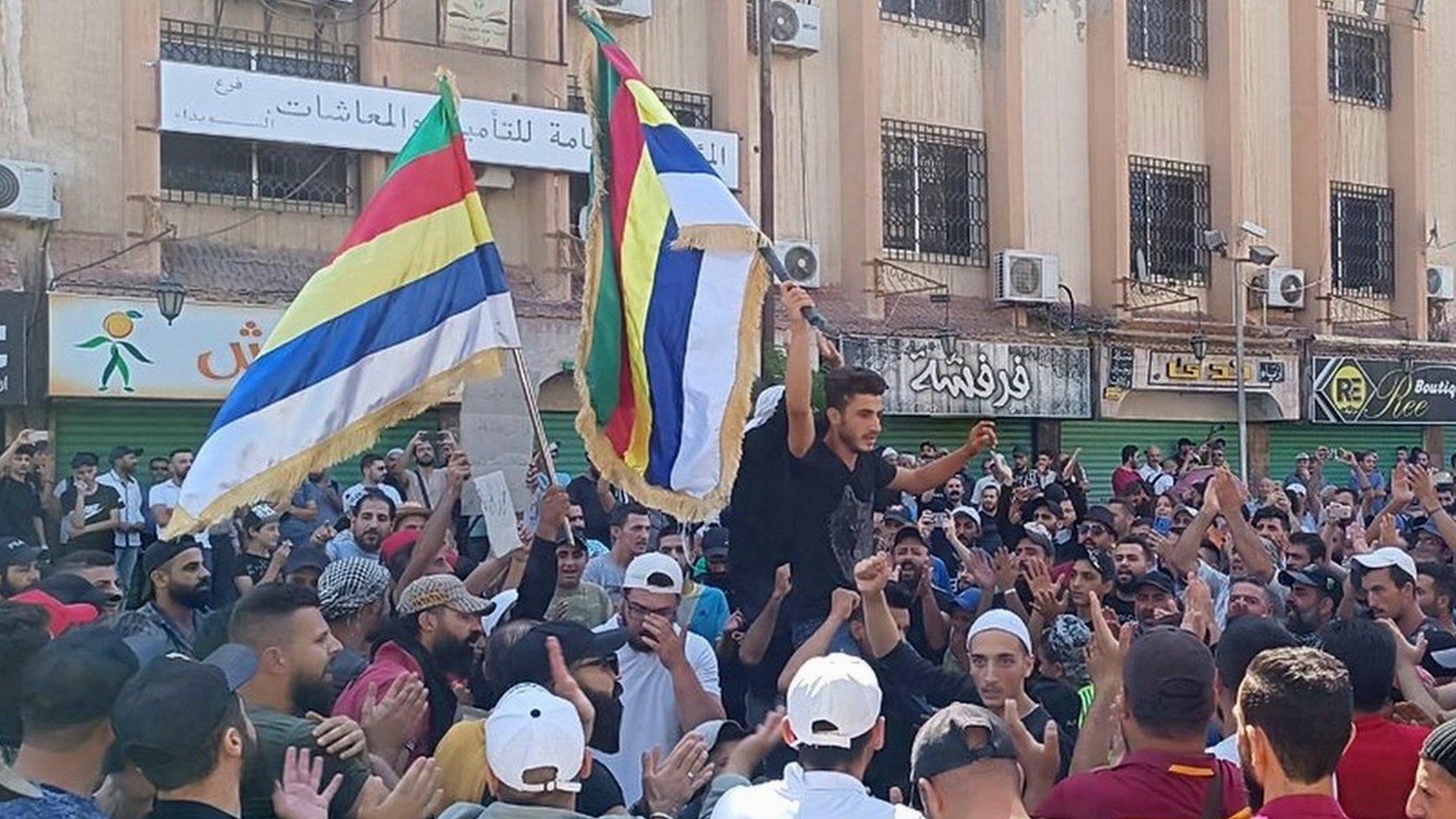 People take part in an anti-government protest in al-Sayr square in Suweida, southern Syria (22 August 2023)