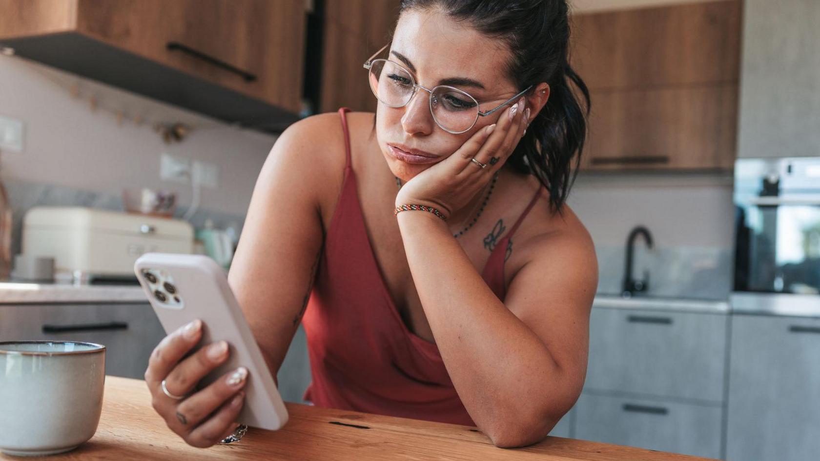 A woman looks at a mobile phone.