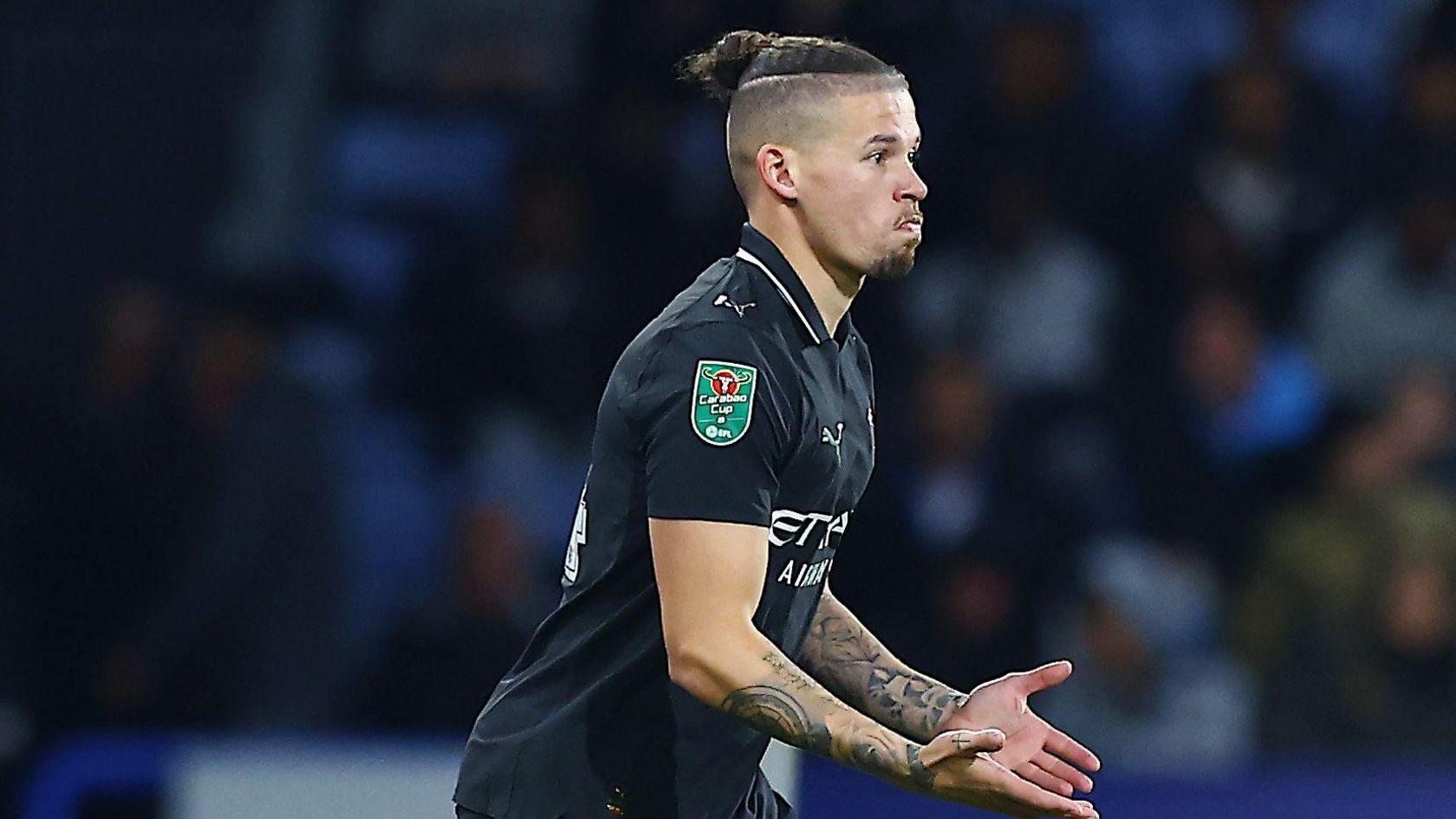 Kalvin Phillips playing football while wearing a black Manchester City away shirt