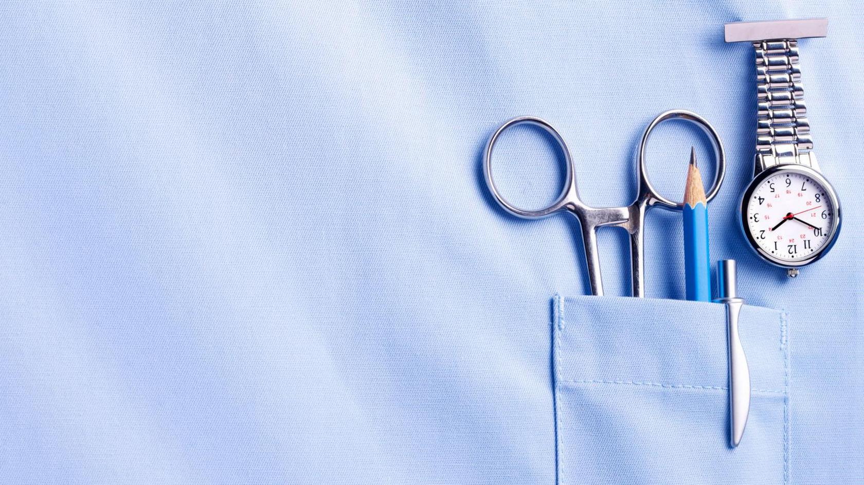 A picture of a nurse's pocket with scissors, a pencil, a pen and a watch in it.