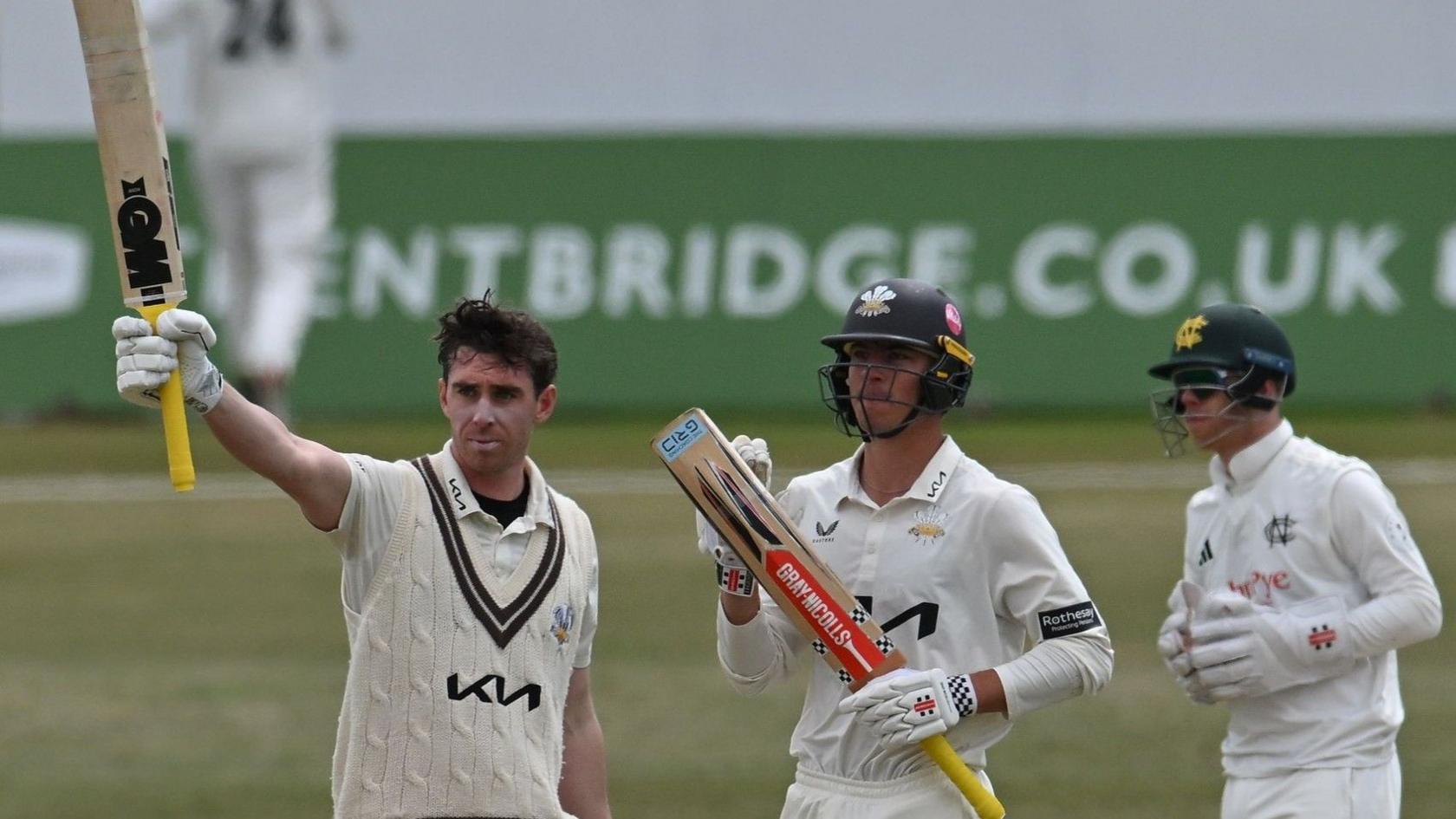 Surrey's Dan Lawrence raises his bat at Trent Bridge after completing a hundred against Nottinghamshire