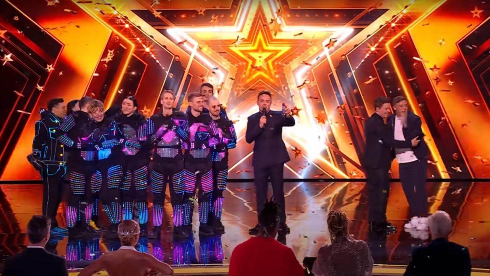 Ant and Dec stand on the stage with The Blackouts and Harry Moulden as they announce the winner