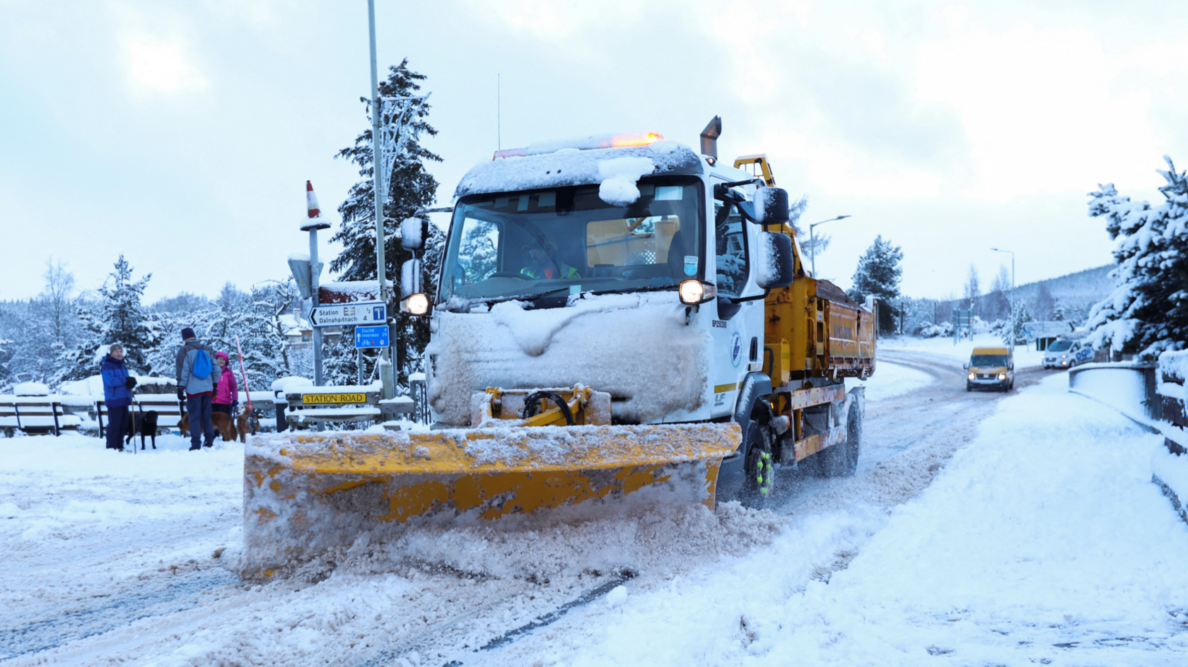 A snow plough clears the road in Carrbridge