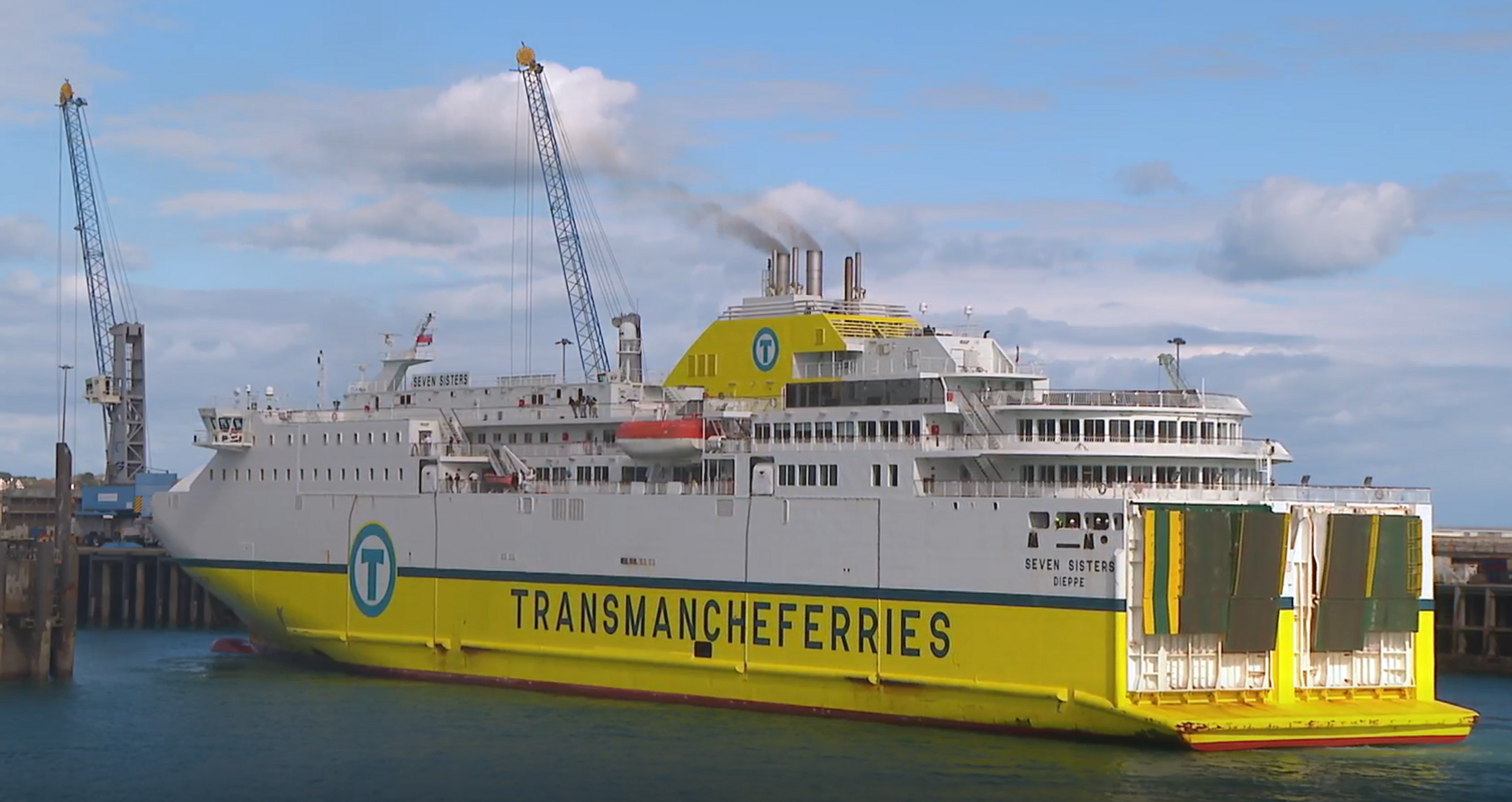 The Seven Sisters ship which is a large white and yellow passenger ferry. It is at port in Jersey. 