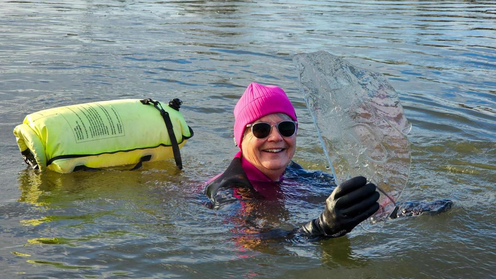 An image of Bridget Betts holding a piece of ice whilst swimming at Spring Lakes