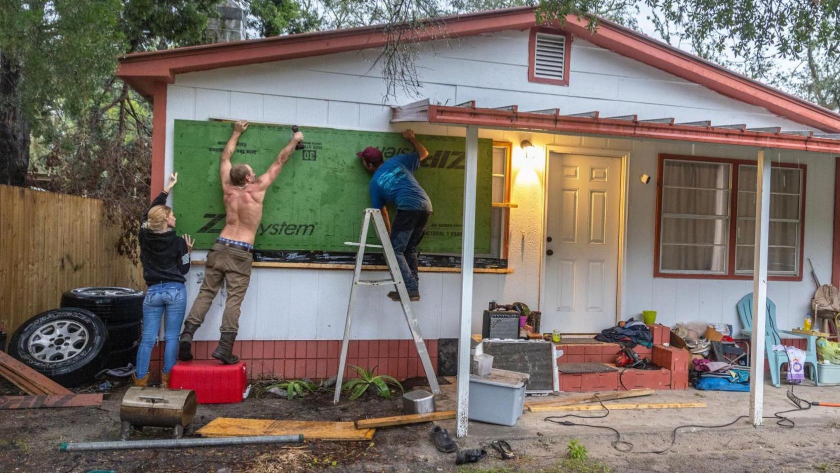 People boarding up windows to prepare for Hurricane Helene, in Old Town, Florida 
