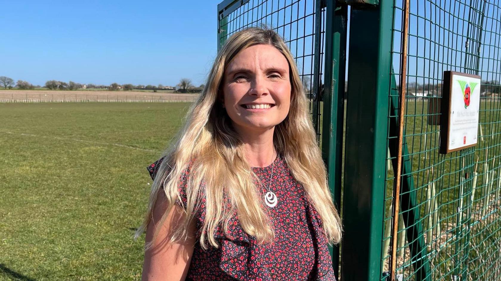 Emily Hollis MBE, Director of The  Hive Thanet, stands by the perimeter fence of the full size football pitch at Foreland Fields