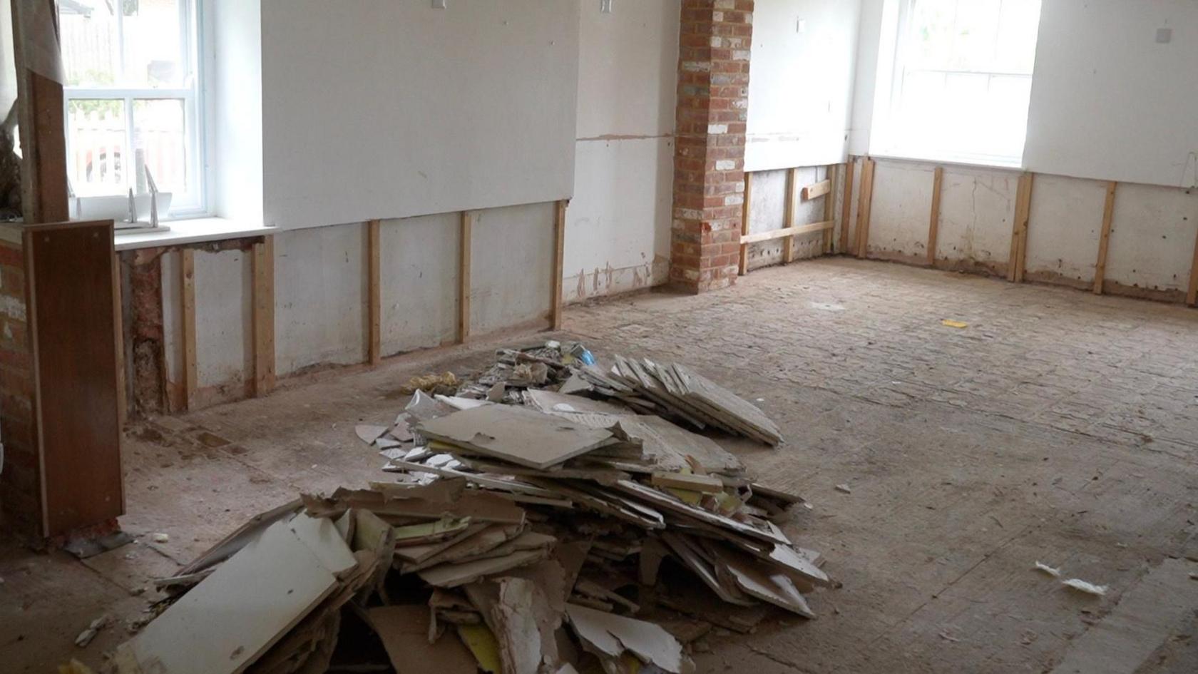 The main reception area at Debenham Veterinary Practice. The floor and walls are bare. In the middle, there is a pile of plaster board. 