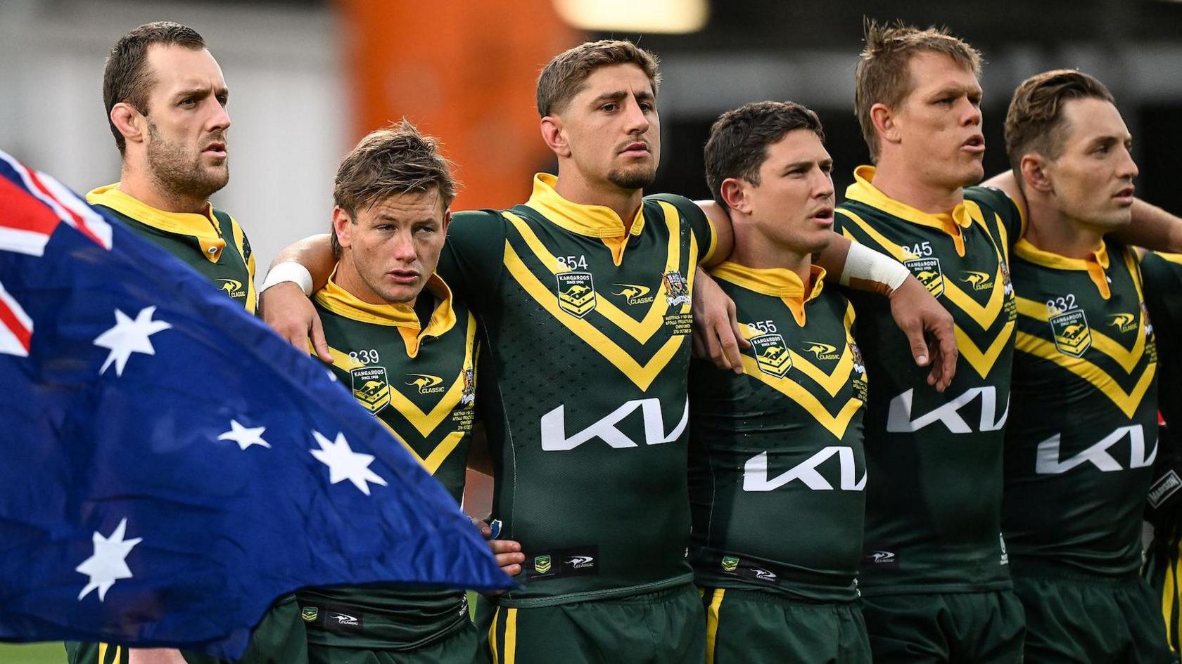 The Australia players stand shoulder to shoulder while waiting to sing their national anthem before the Test with New Zealand