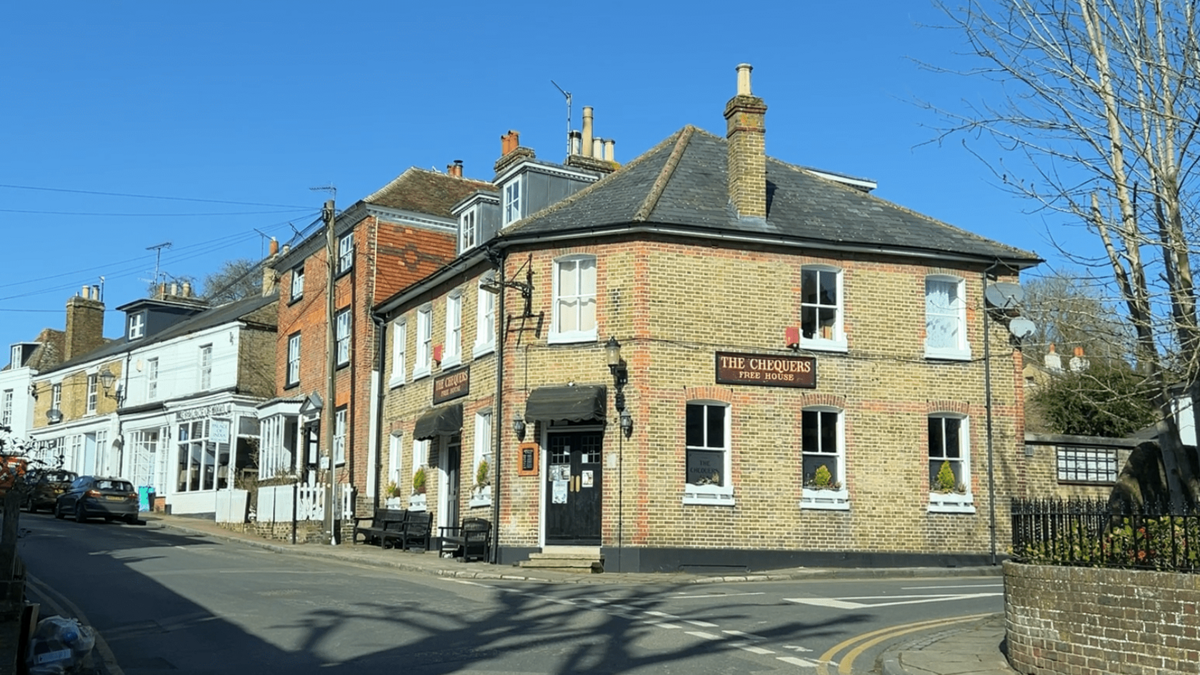 A pub on corner with The Chequers written on the side.