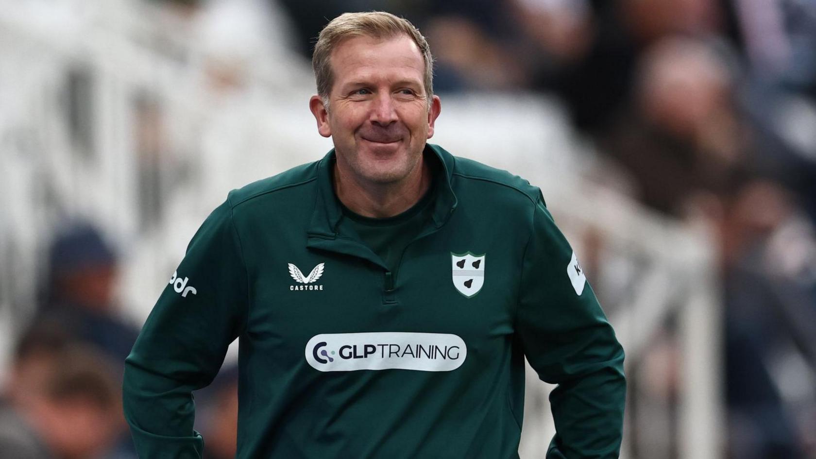 Worcestershire head coach Alan Richardson smiles in his green club training top as he walks round the boundary