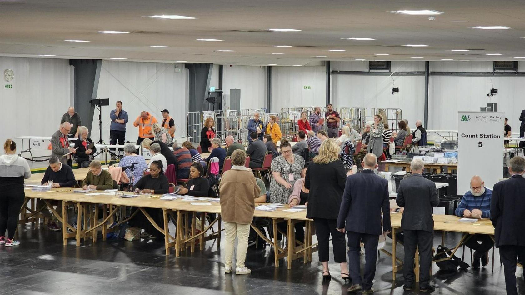 Lots of people counting ballot papers in room in Amber Valley