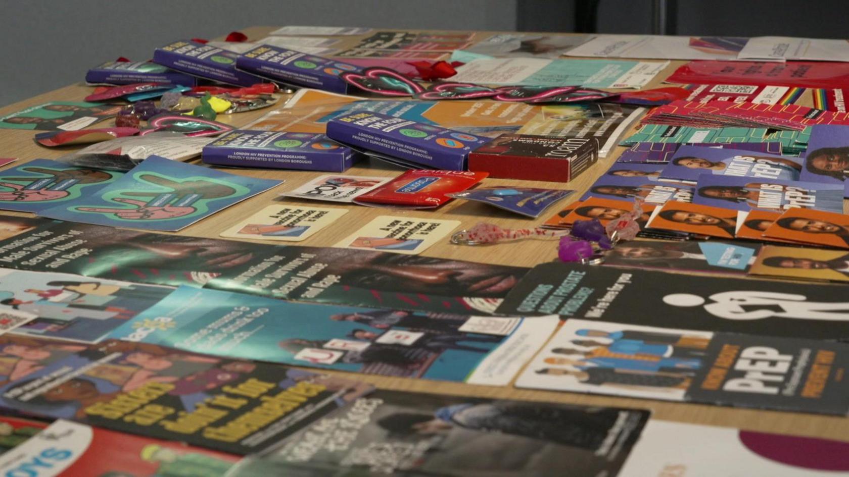 A table covered with various leaflets and information on sexual health services