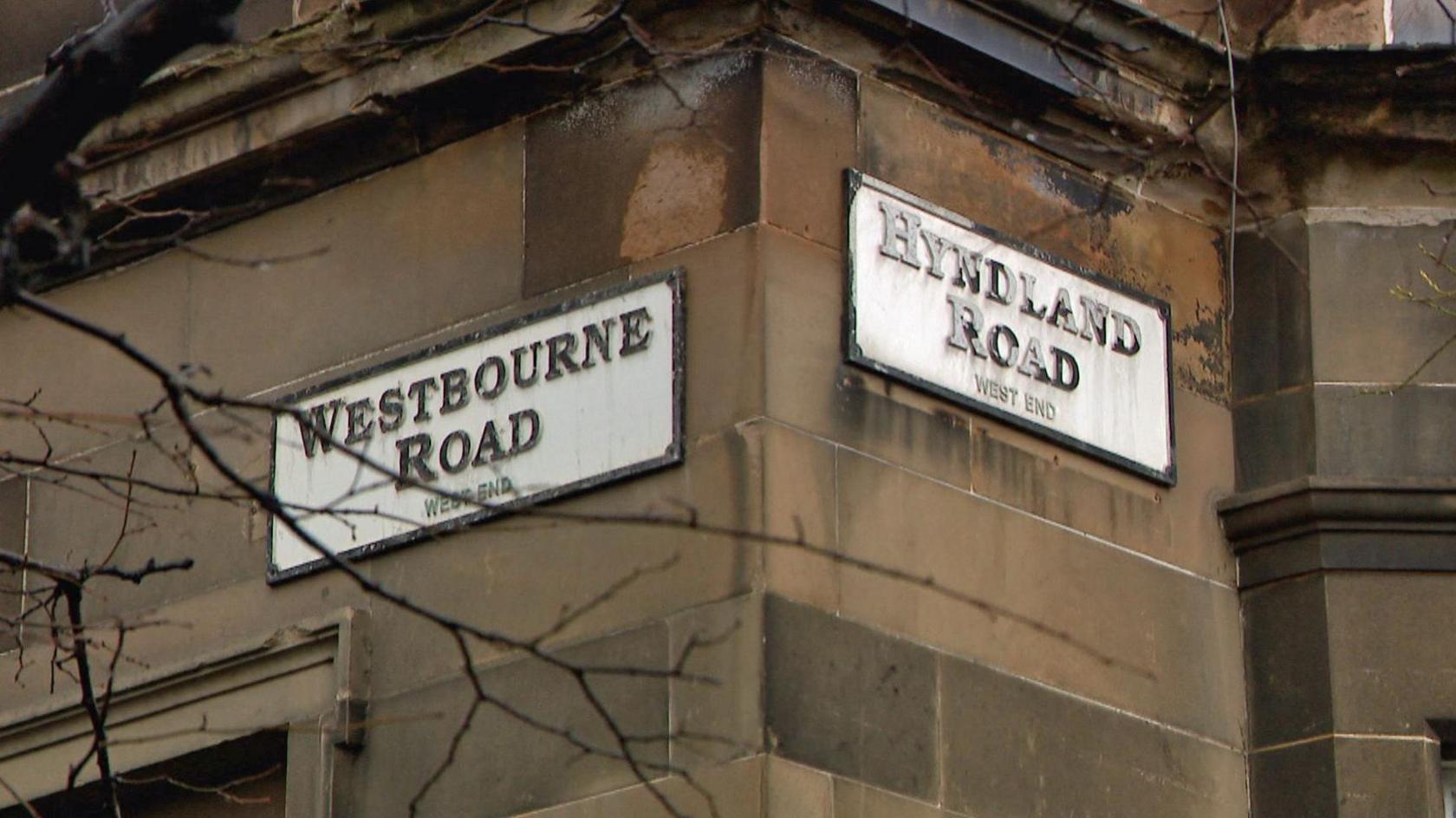 Street signs for Westbourne Road and Hyndland Road on a sandstone building