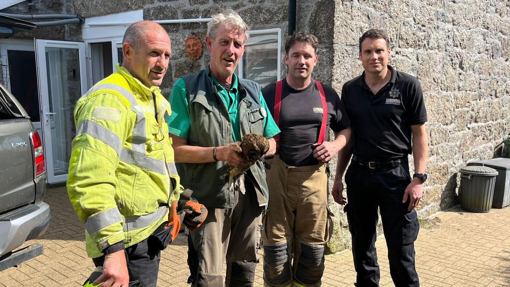 Firefighters with Nick Reynolds after rescuing the owl stuck in a chimney