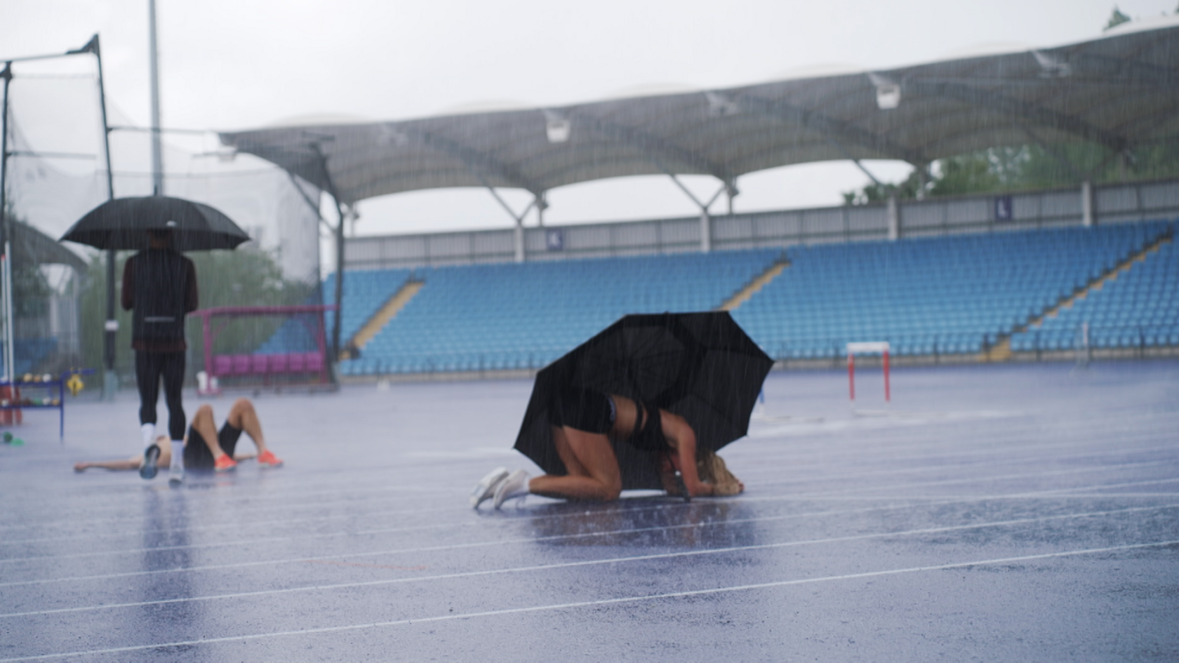 Keely Hodgkinson lies on the ground after completing a track session in the Manchester rain