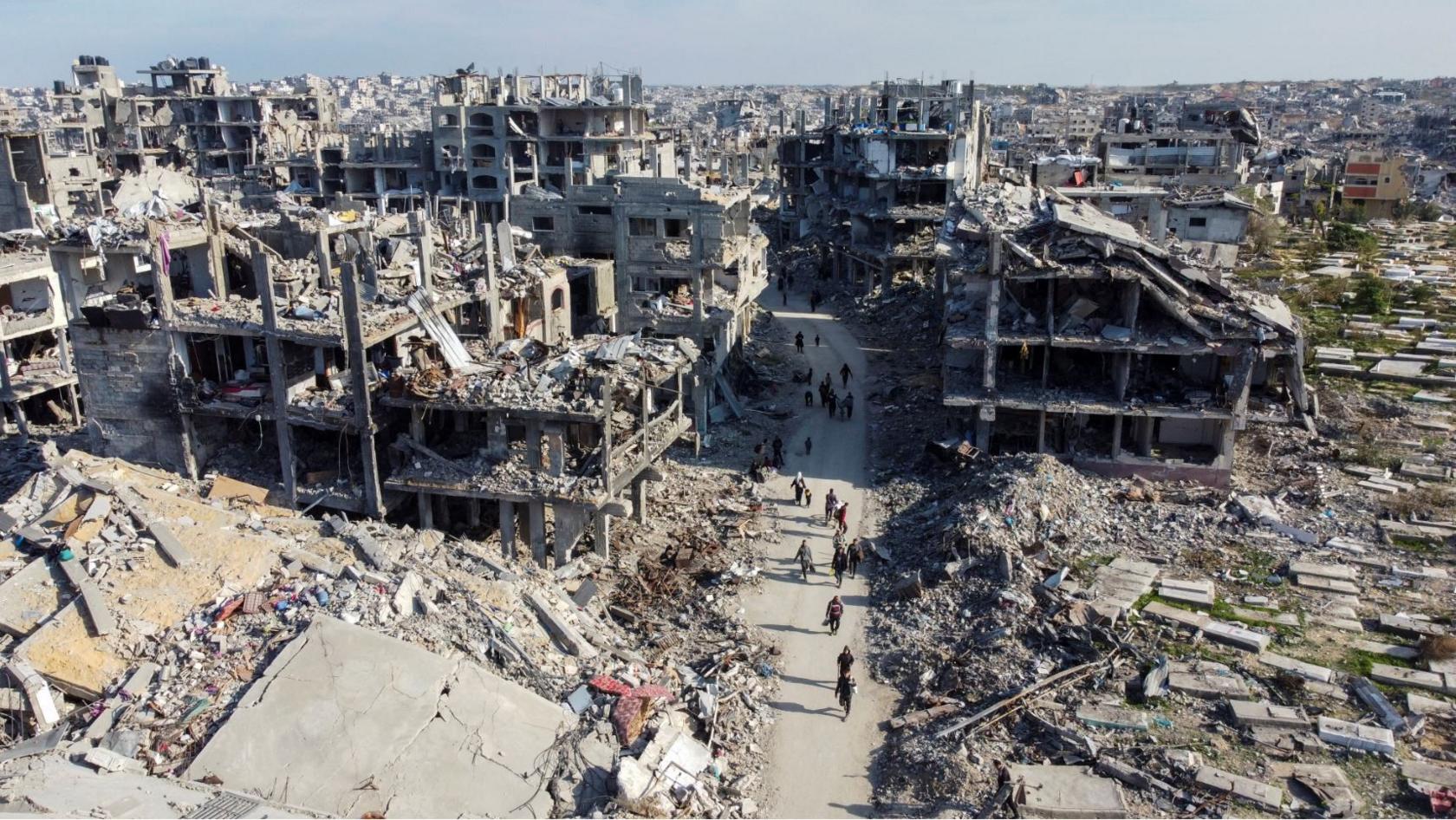 A drone shot of Jabalia showing damaged buildings and people walking among them 