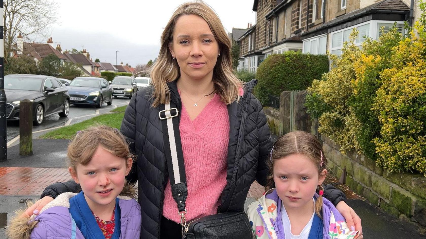 Caroline and her children Erin and Amelia stood on the footpath