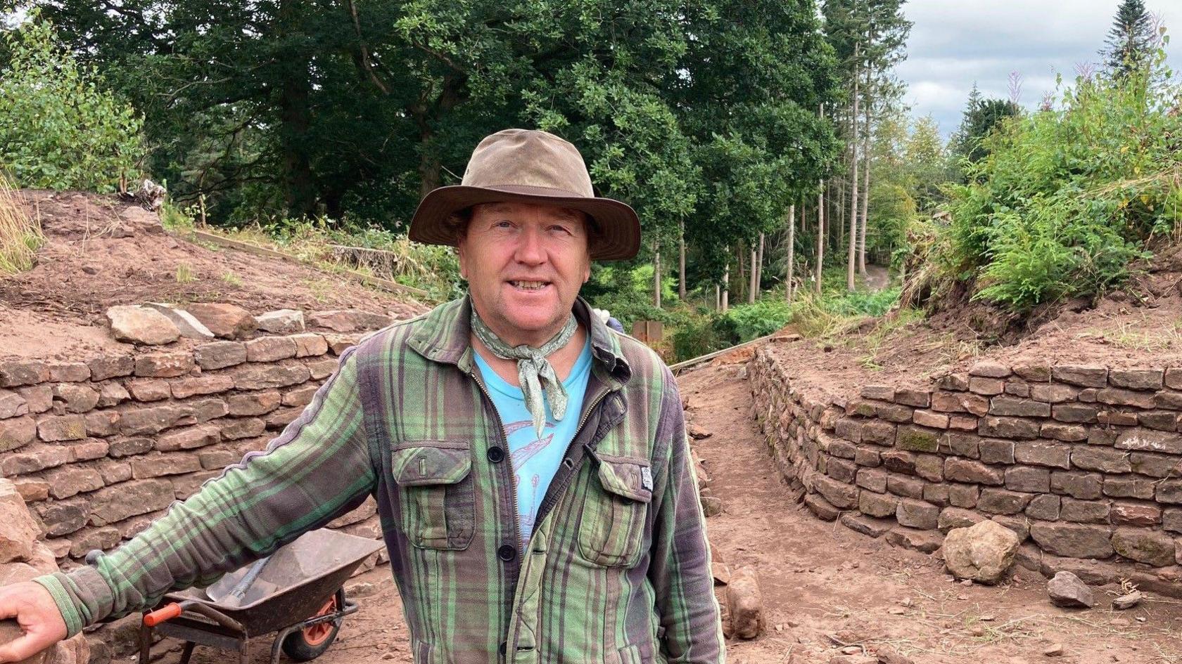 Dr Paul Reilly standing at the entrance to the hillfort