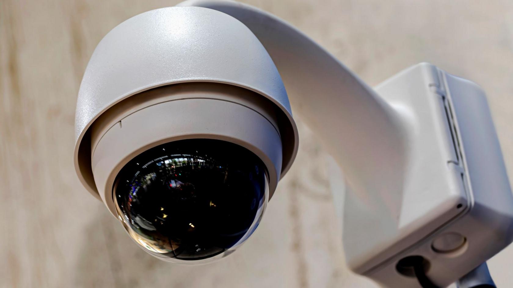 CCTV camera, covered by a semi-circular black casing.