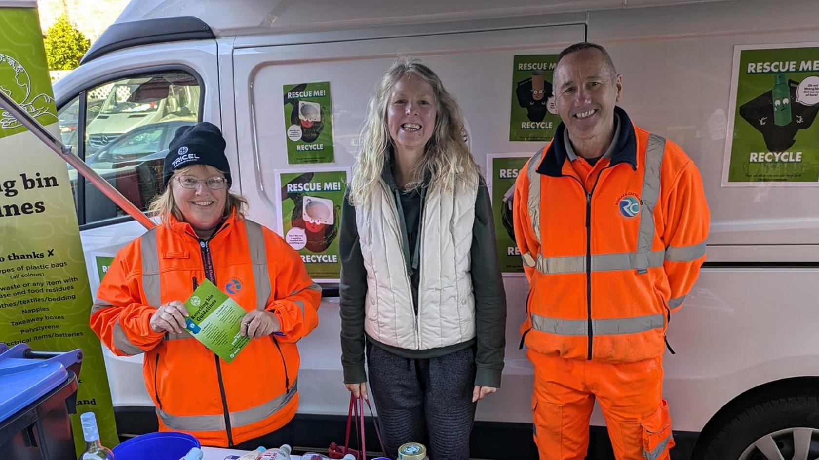 Carolyn Curr with two people at a stand promoting recycling