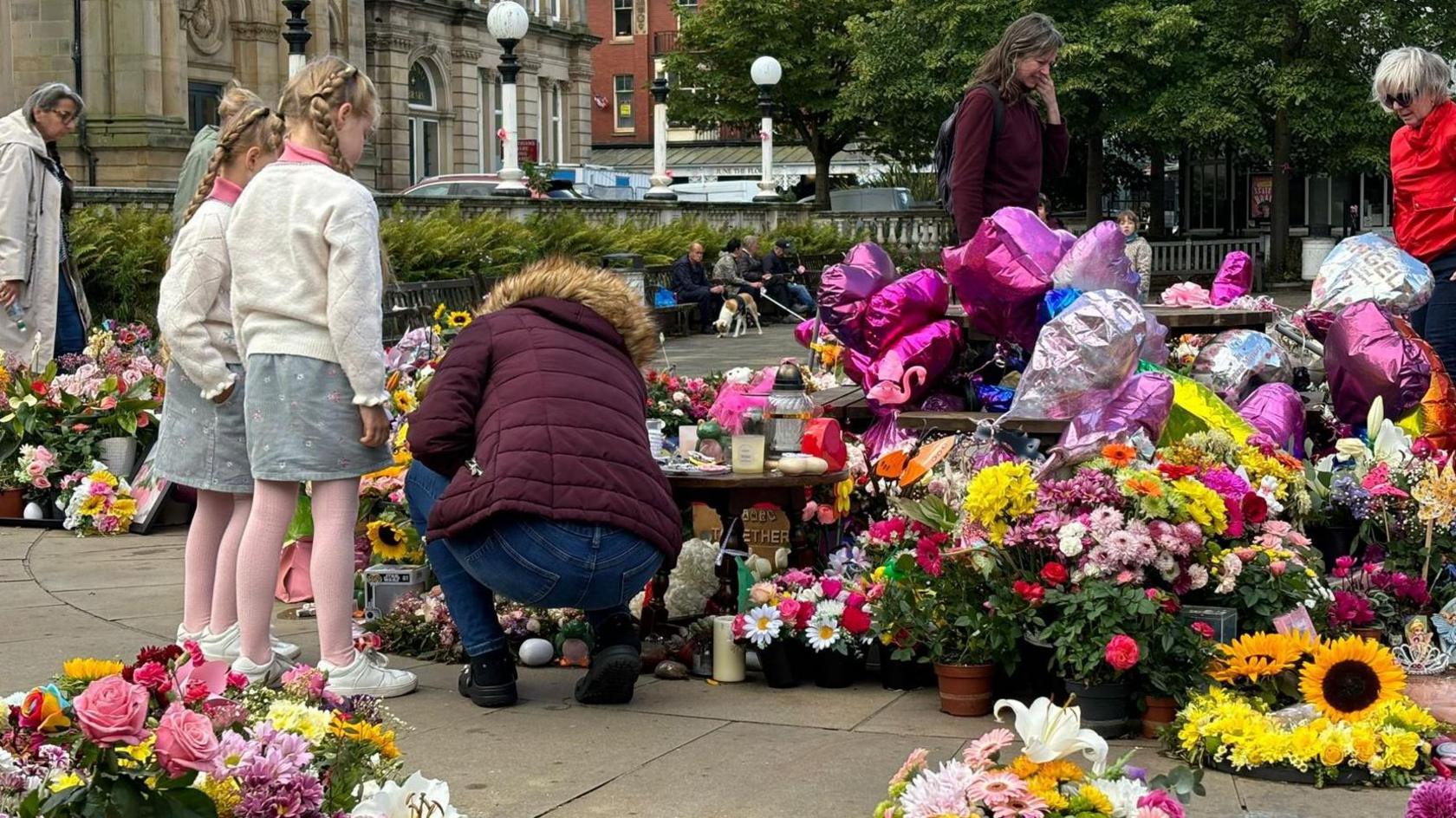 Children laying flowers in Southport Town Centre