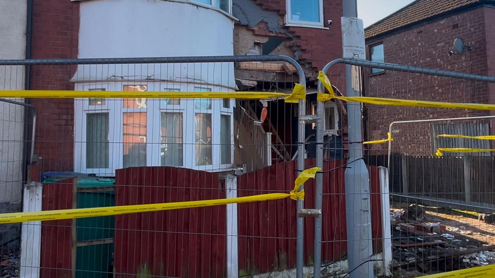 Metal fences with yellow cordon tape surround the property after the crash.