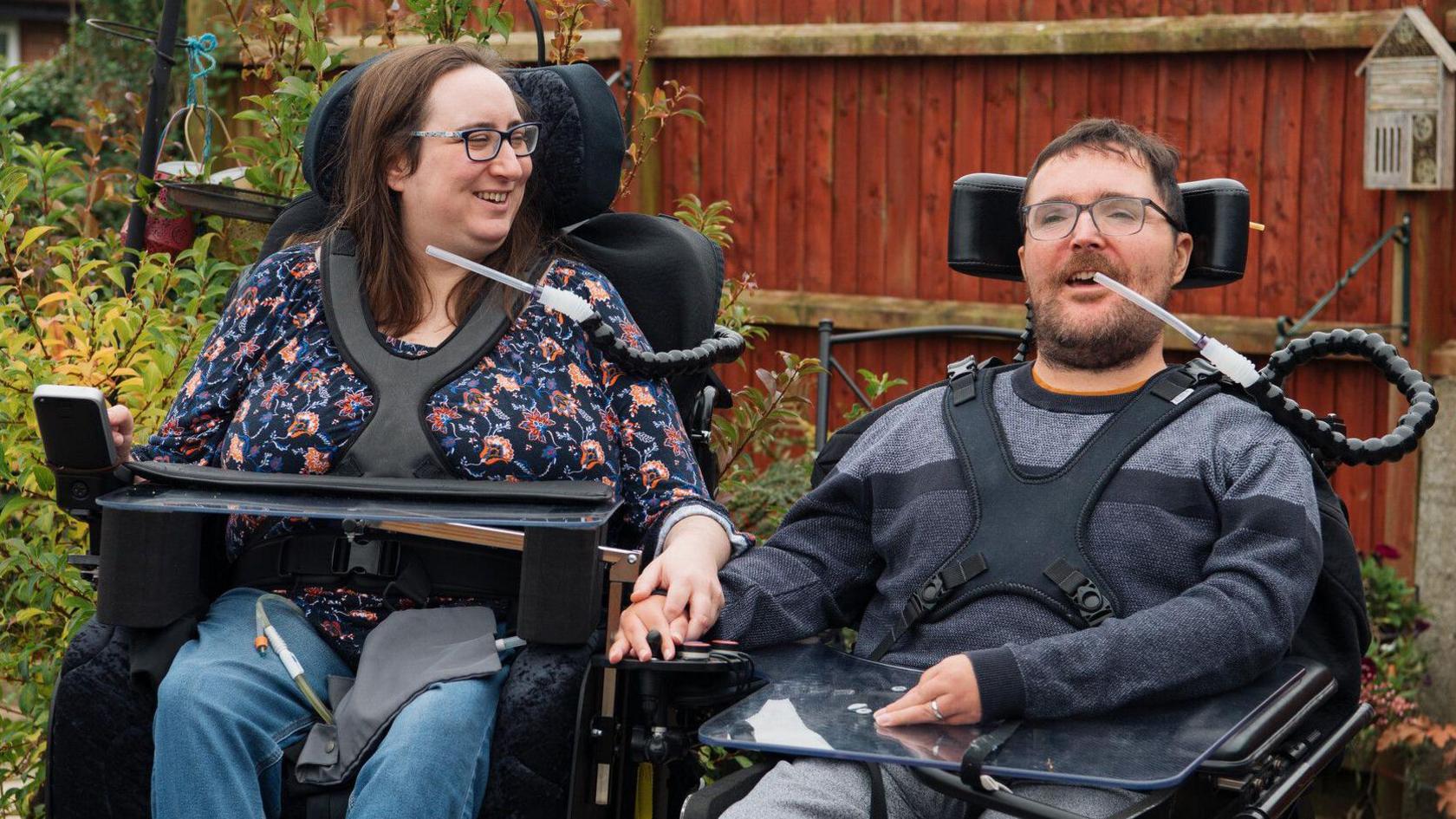 Charlotte and Tom Hardwick sitting in their wheelchairs in a garden