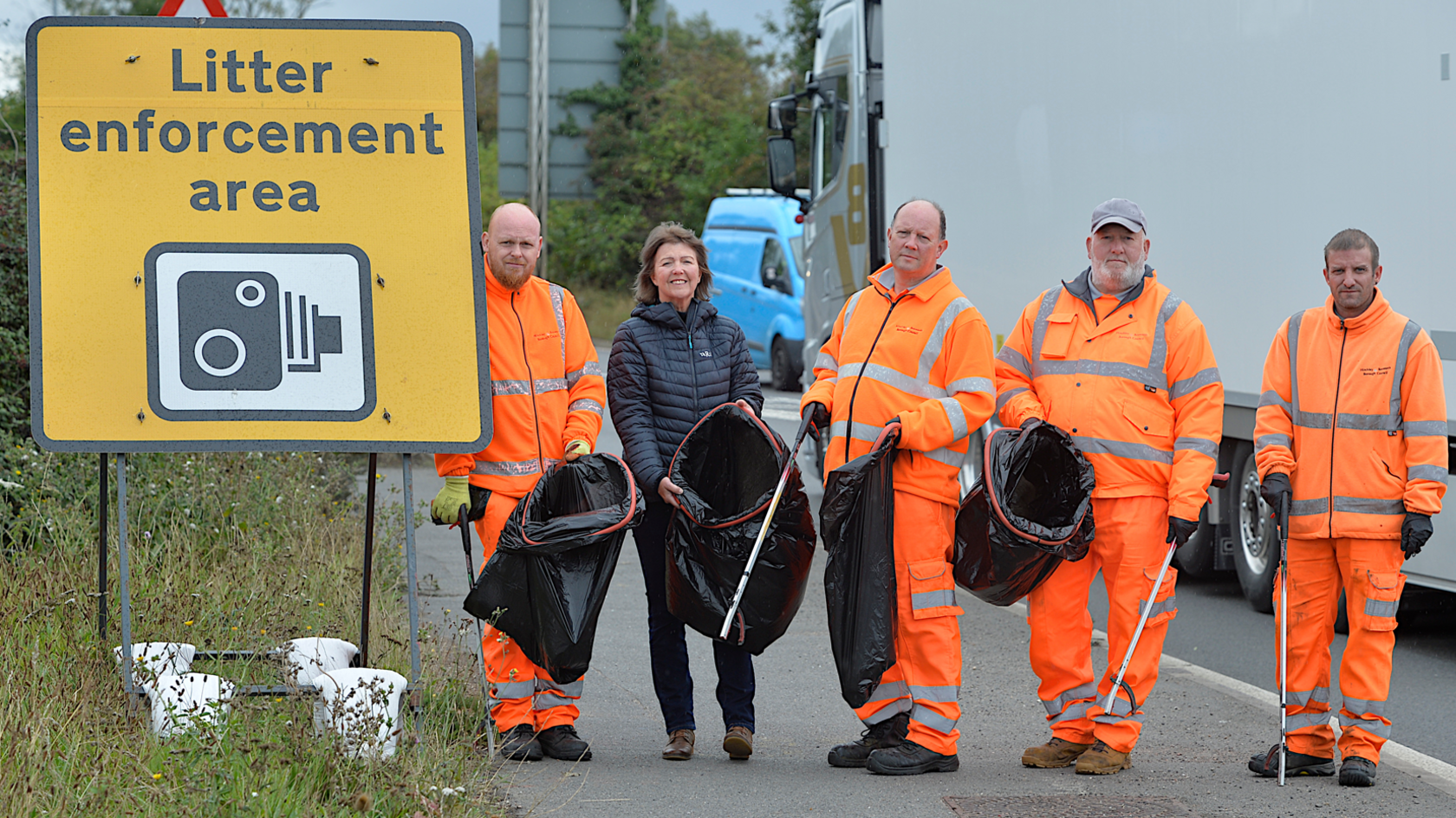 Hinckley & Bosworth Borough Council litter picking crews on the A5 standing next to the litter enforcement area sign