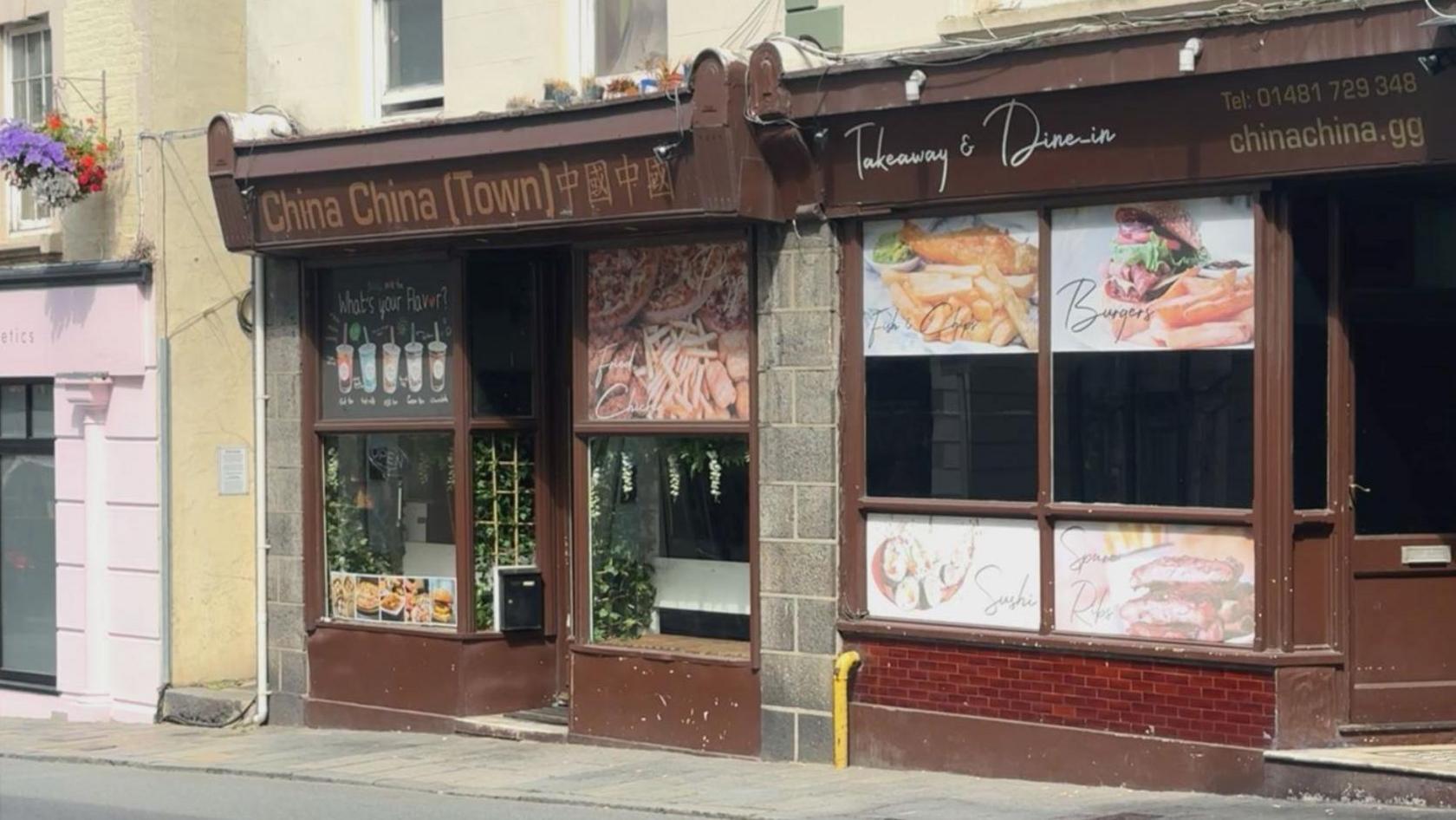 A brown shopfront of a takeaway restaurant with a sign saying China China (Town) Takeaway and Dine-In. Pictures of food on the windows including Chinese food and burgers.