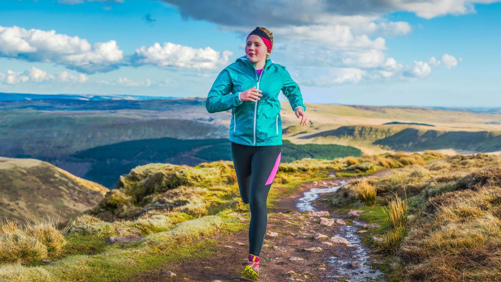 Girl running through hills.