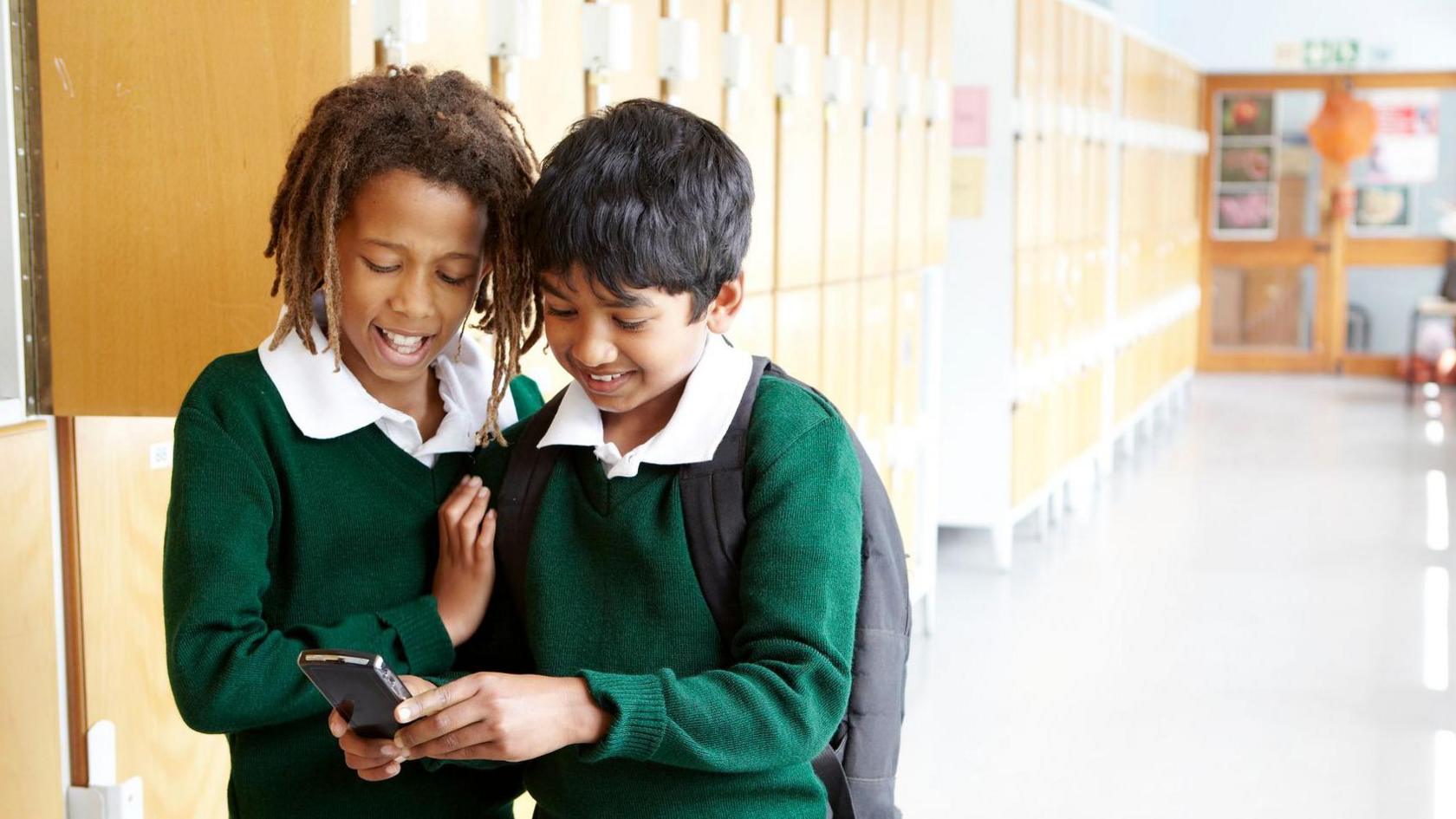 two boys looking at mobile phone. 