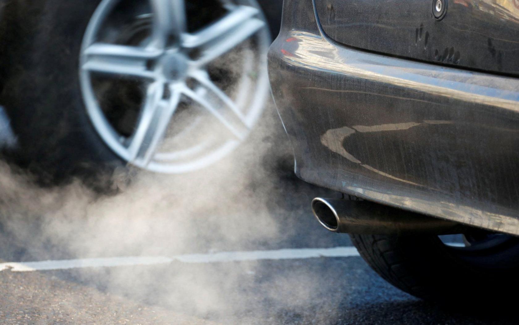 The picture shows a plume of white fumes coming out of a car's exhaust pipe