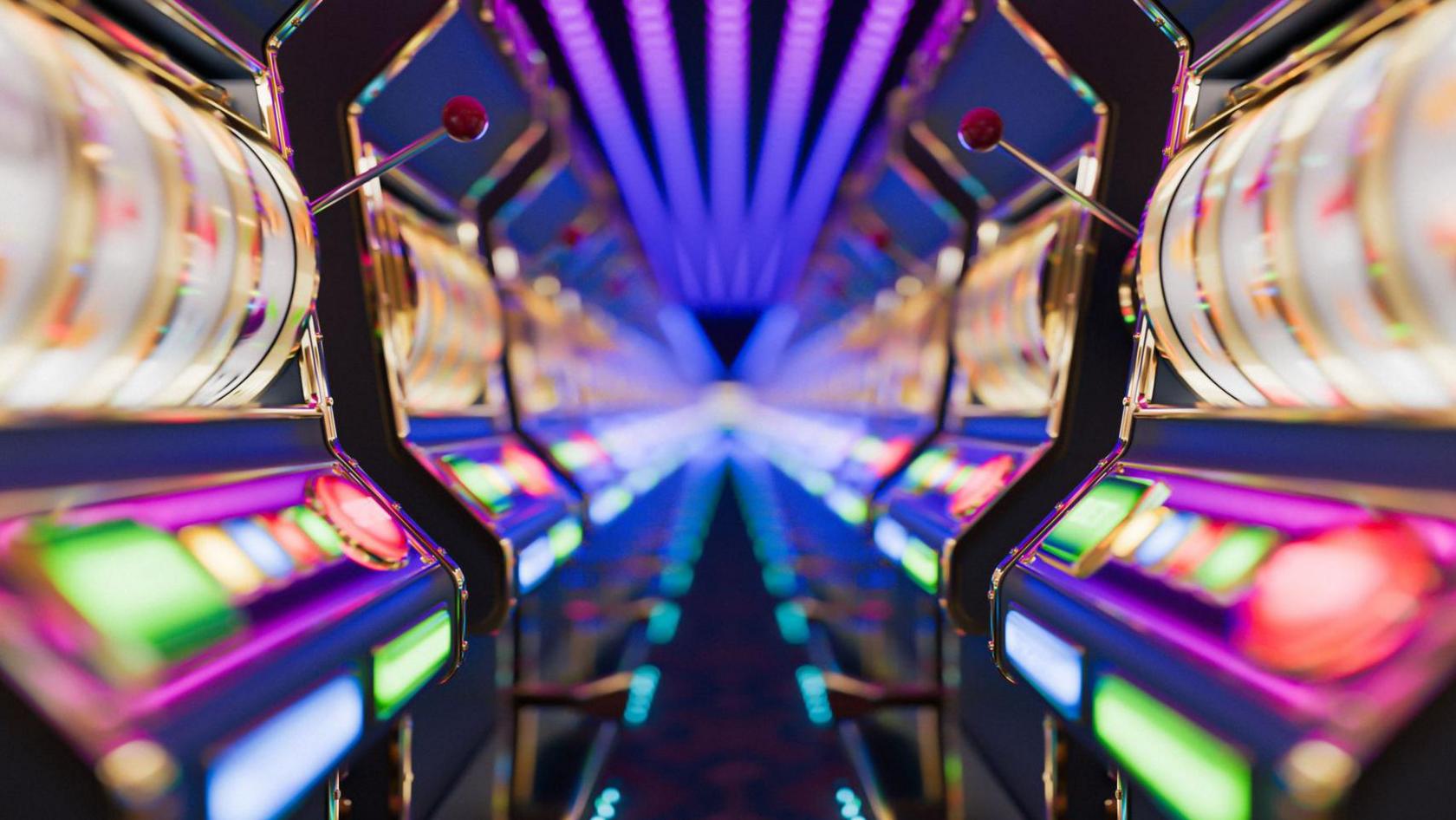A blurred image of neon coloured lit-up arcade games which are in a row.