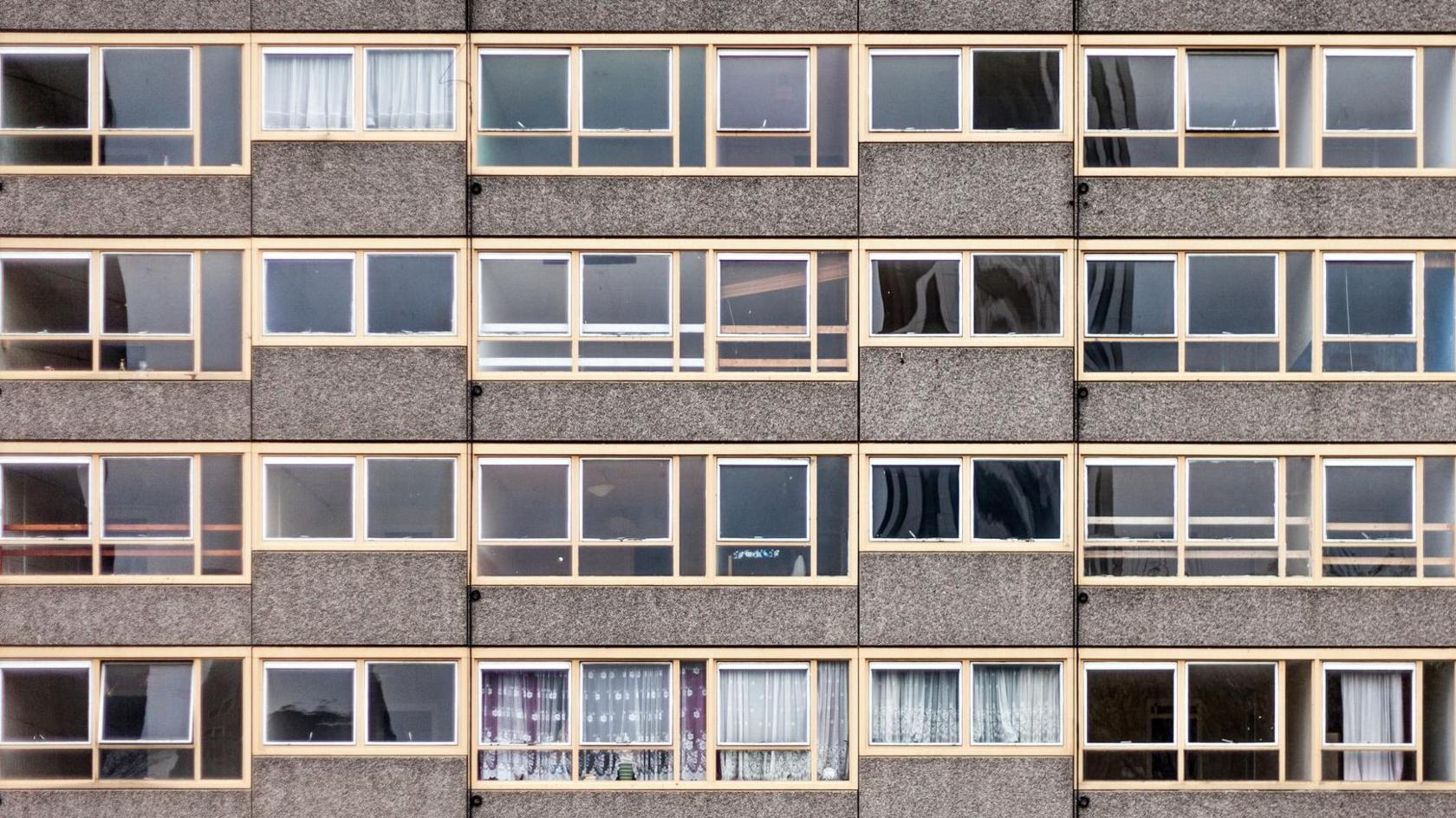 Close up of windows in a gray run down council block. 