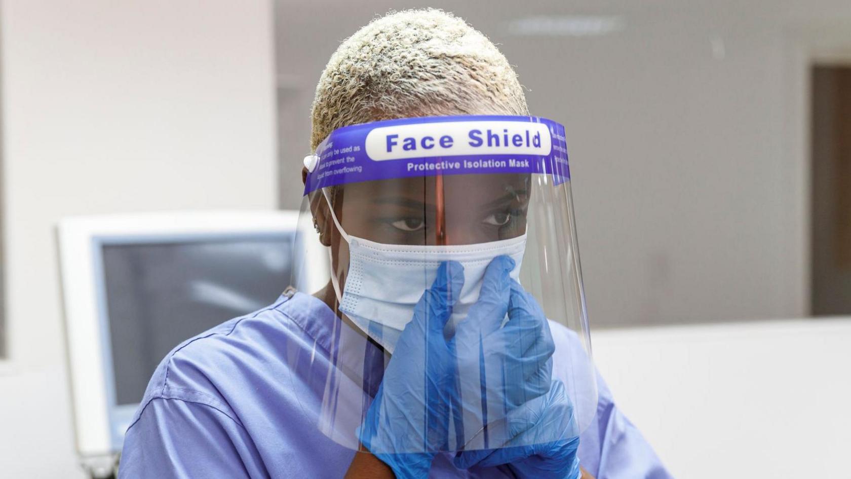 Stock picture of healthcare worker wearing a surgical mask and face shield during the pandemic.