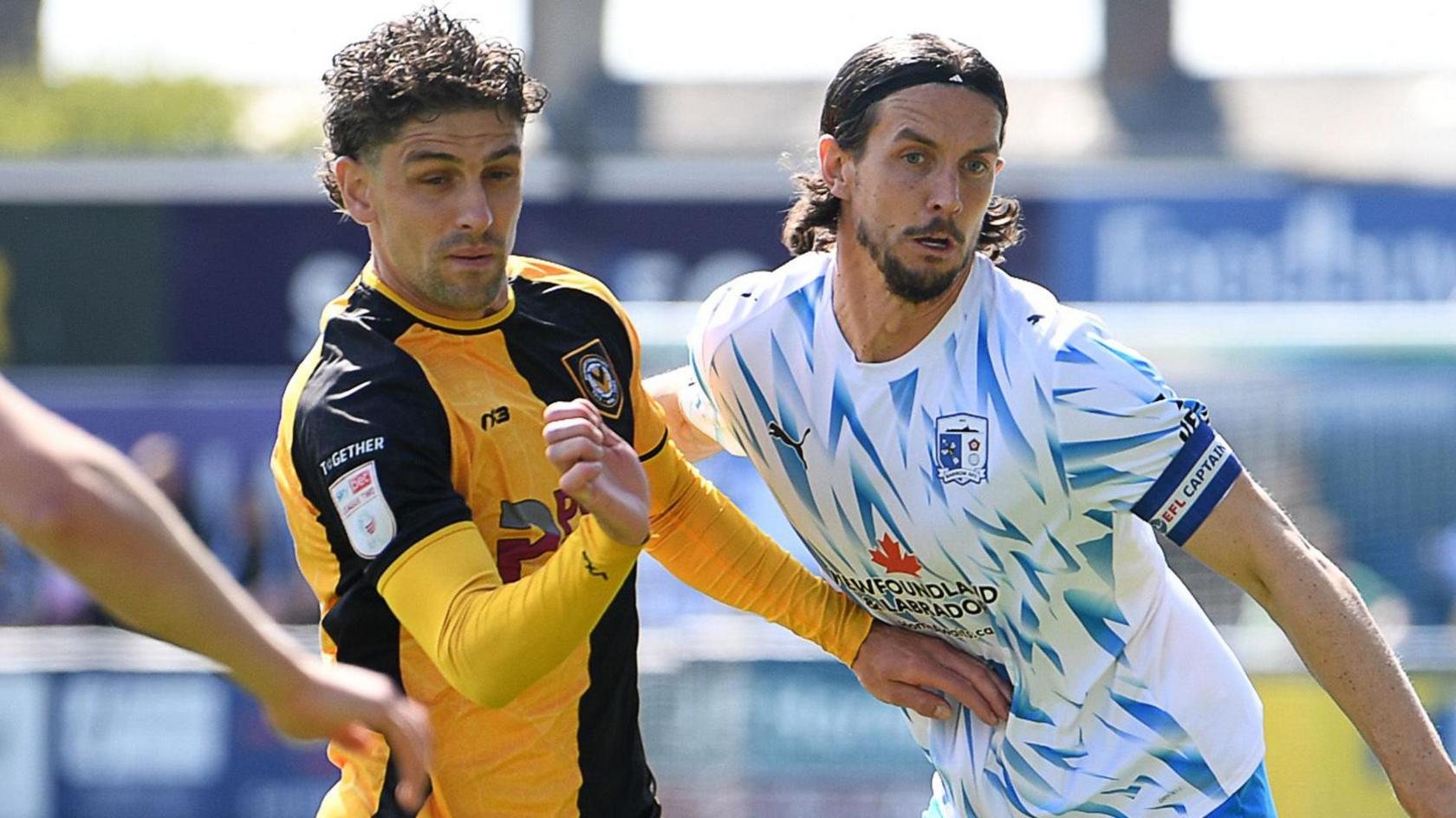 Harrison Biggins (left) of Newport County is challenged by MJ Williams of Barrow 