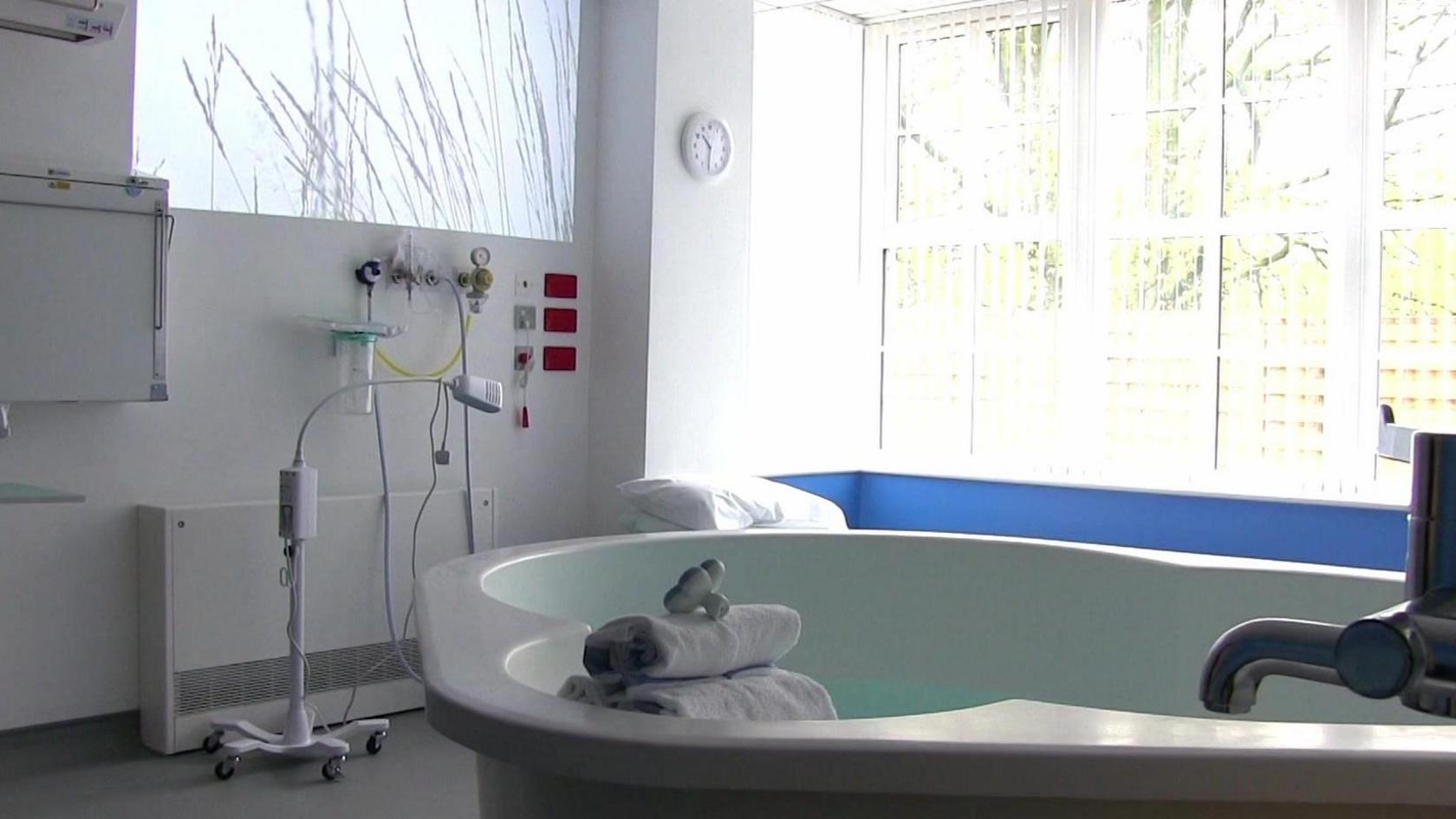 An interior view of a room at Ingleside Birthing Community Centre showing a birthing pool and a large window