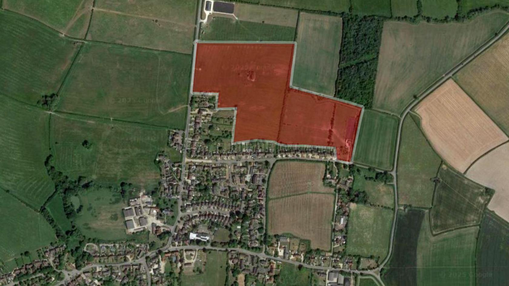 A Google maps image of Marsh Gibbon, a medium-sized village with fields surrounding it. A red shaded area on the northern edge of the housing indicates where new homes would be built.