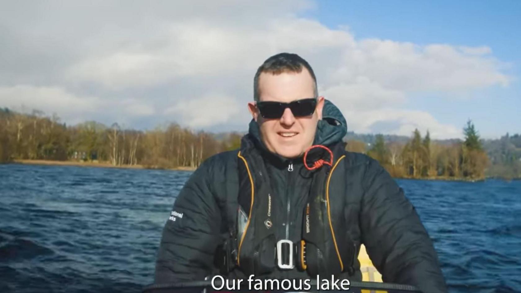 A man in a kayak on Coniston Water with the subtitle "our famous lake"