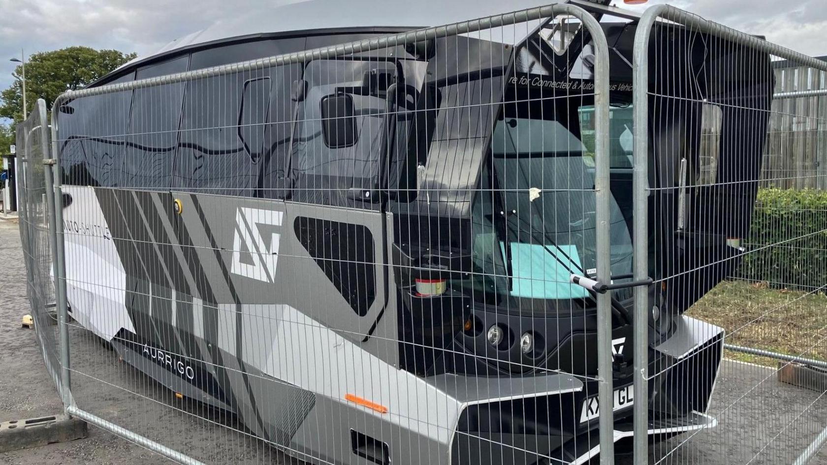 Driverless bus behind fencing at Inverness Campus before it was vandalised