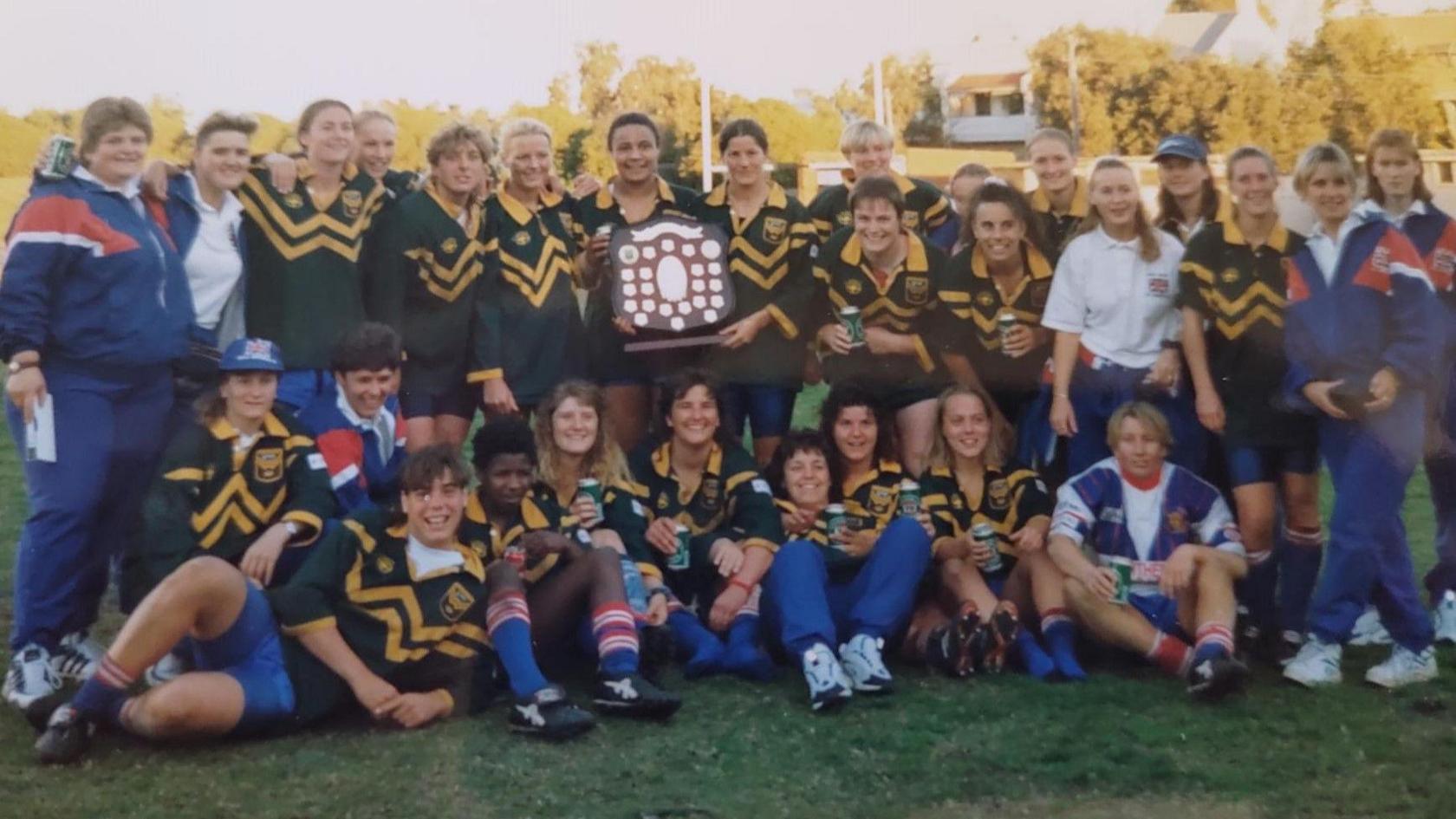 Great Britain's players gather on the pitch for a team photo to show off the shield they won for beating Australia